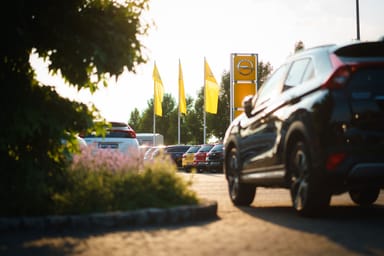 Mehrere Fahrzeuge auf dem Außengelände des Autohauses Strauch in Rüdersdorf, mit gelben Opel-Fahnen und dem Opel-Logo im Hintergrund.